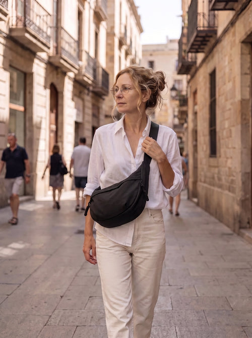 Mujer caminando por una calle del casco antiguo con el bolso Nara cruzado por delante