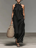Vestido largo Elia en negro, de cuello halter y con volantes laterales, visto de frente