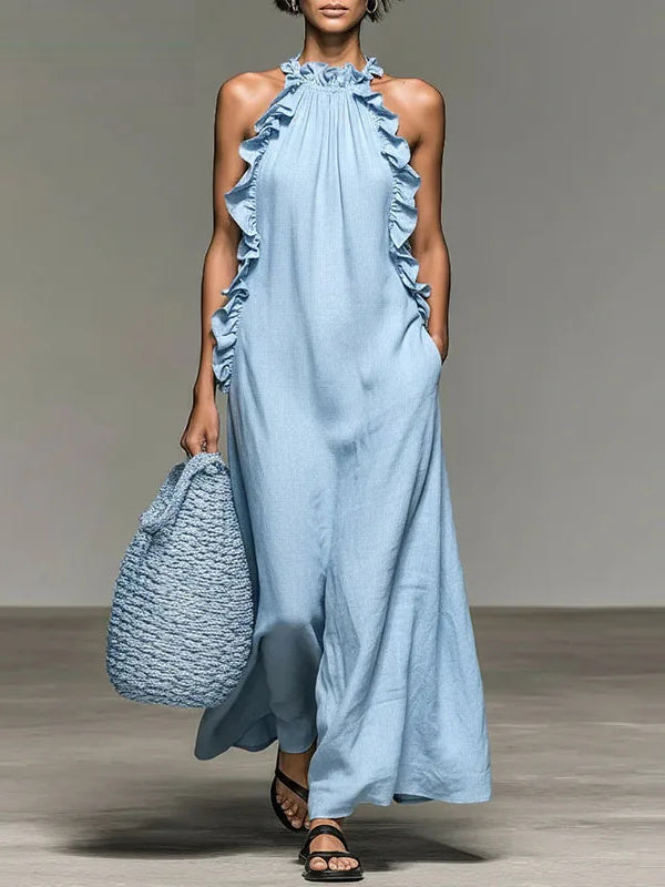 Vestido largo Elia en azul claro, de cuello halter y con volantes laterales, visto de frente