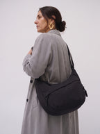 Mujer de perfil con el bolso Nara negro al hombro