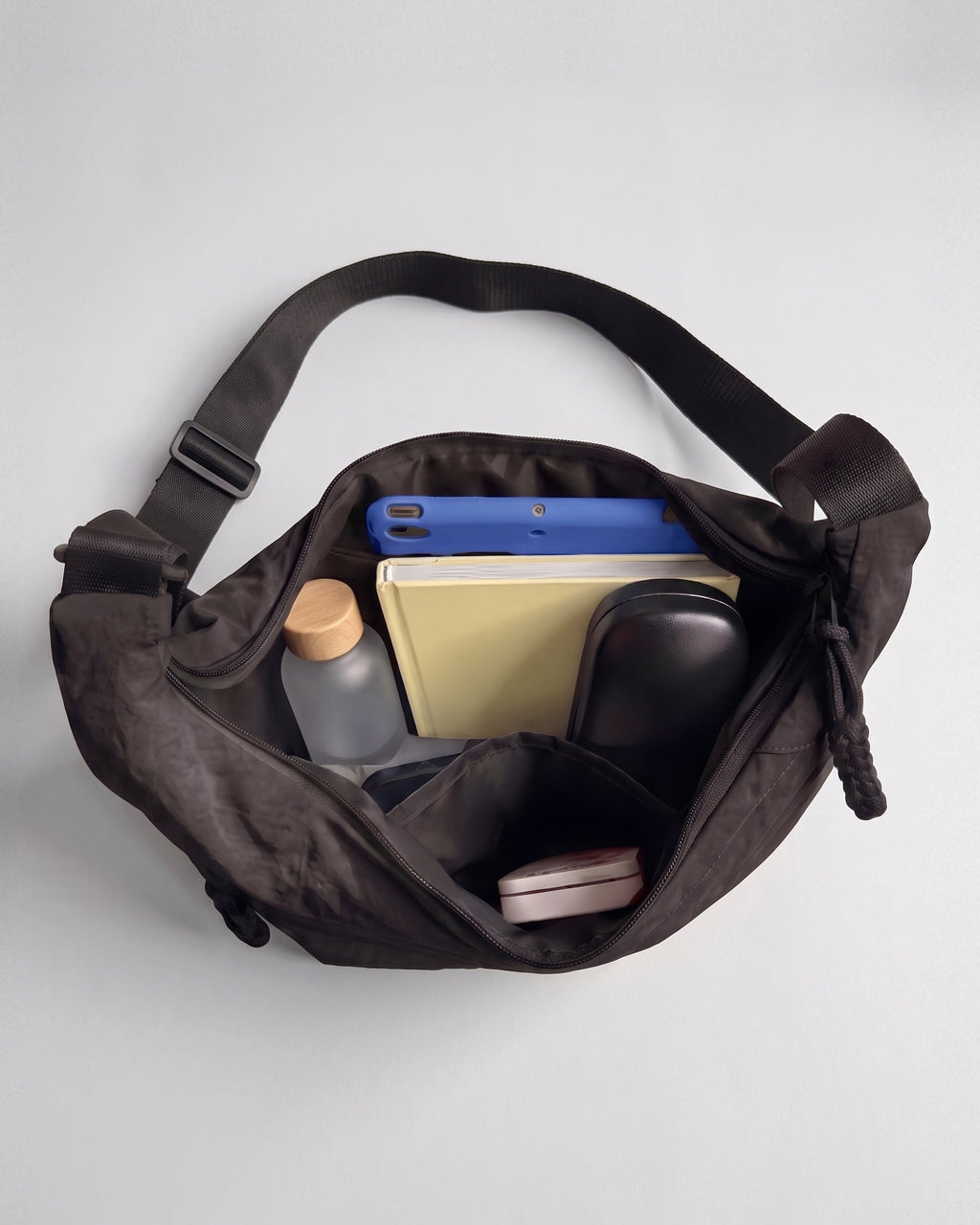 Interior del bolso Nara abierto: tablet, libreta, botella, gafas y bolsillos