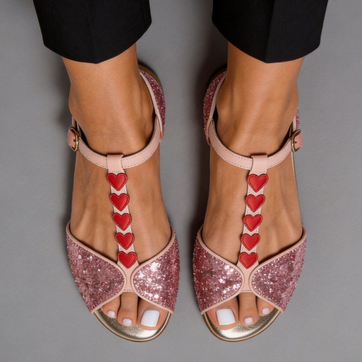 Sandalia rosa en T con brillos y corazones rojos