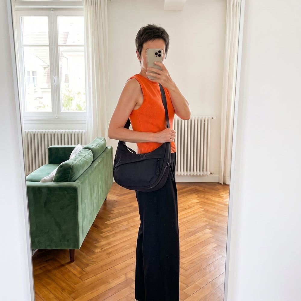 Clienta con top naranja y el bolso Nara negro