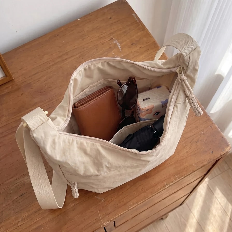 Interior de la bandolera Senaroa Nara en blanco crema con cartera, gafas, pañuelos y paraguas dentro